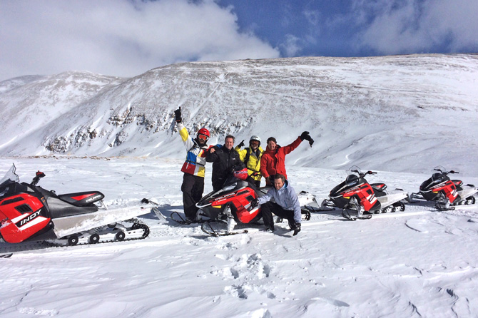 Group of snowmobilers with High Country Tours on a mountain ridge in Summit County, Colorado