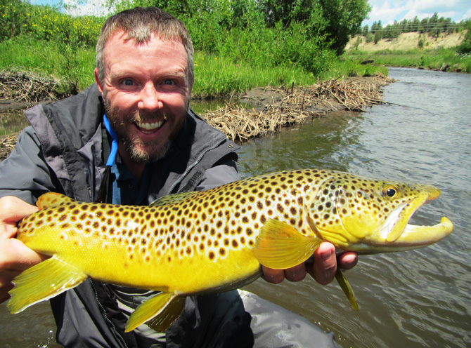 Fisherman showing off his catch with Colorado Tout Hunters Fly-Fishing Guide in the Denver Mountain Area