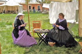 Two women knitting in traditional 1900's clothing in Fort Garland, Colorado. Explore 5 original adobe buildings. All in Conejos County, Colorado.