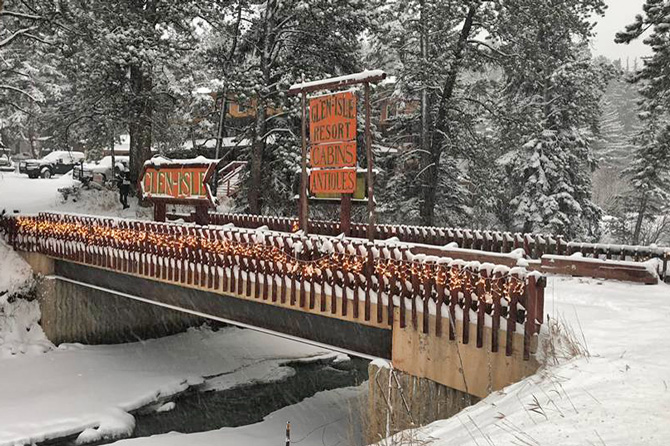 Bridge crossing a snowy river at Glen-Isle Resort Lodge and Cabins near Bailey and Pine, Colorado