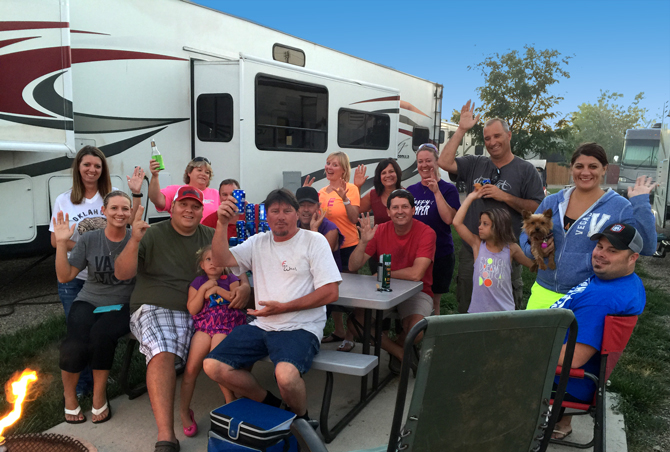 A fun group of people by campfire and RV site at the La Junta KOA