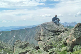 Hiker perched on a rocky seat near Winter Park, Colorado.