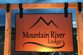 Mountain River Lodge entrance sign at dusk in Lake George, Colorado