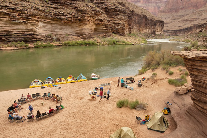 People camping and preparing to raft on the shore of a river with O.A.R.S. Colorado Rafting, Authorized Concessionaire of Dinosaur National Monument, near Dinosaur, Colorado