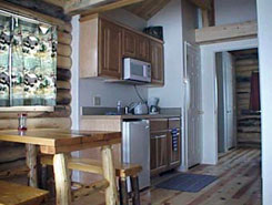 View of kitchen and dining area inside cabin at Muddy Creek Cabins in Kremmling, Colorado