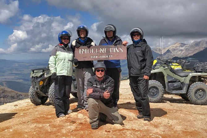 Five people standing by Imogene Pass sign with ATVs rented from San Juan Backcountry Tours and Rentals, in the Silverton Area, Colorado. Explore the Regal San Juan Mountain Backcountry on UTVs, ATVs, 4x4s, and Jeeps. Experience the best hikes and fishing in Silverton, Colorado.