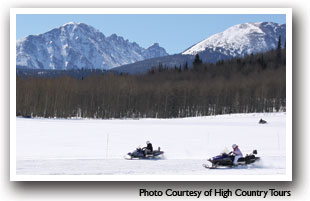 Snowmobiling in Summit County, Colorado with mountains in the background, photo courtesy of High Country Tours