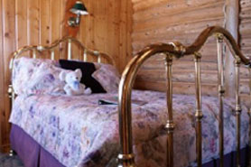 Interior of romantic and cozy room with brass bed at Allenspark Lodge in Allenspark, Colorado