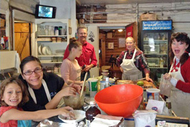 People in kitchen cooking together inside Allenspark Lodge, near Estes Park, Colorado.