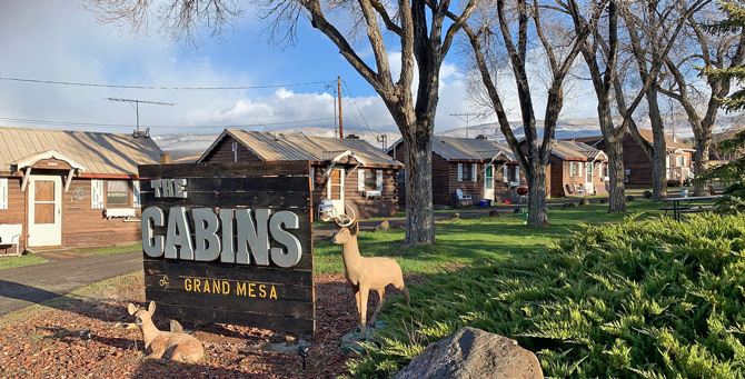 The Cabins of Grand Mesa entrance sign with deers in Grand Mesa, Colorado