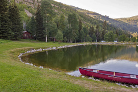 Canoe on shore of private pond at Chair Mountain Ranch Cabins in the Crystal River Valley of Marble, Colorado