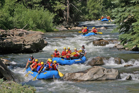 Rafts from Clear Creek Rafting Company float down the Arkansa River near Royal Gorge, Colorado