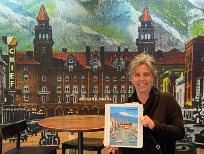 Tour guide posing with their guide book for Colorado Springs Historic Walking Tours in Colorado Springs, Colorado.