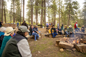 Group of friends and family relaxing around a campfire at Colorado Trails Ranch  located near Vallecito Lake in Durango, Colorado