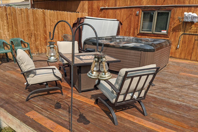 Private outdoor deck with hot tub, chairs and fire pit at Columbine Cabins in Grand Lake, Colorado