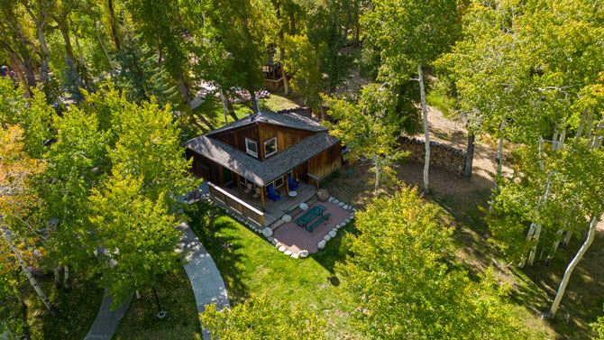 Overhead view of shaded cabin with porch and bbq at Creekside Chalets and Cabins in Salida, Colorado