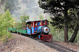 Scenic steam locomotive train ride going through aspens and pine trees at Cripple Creek and Victor Narrow Gauge Railroad in Cripple Creek, Colorado.