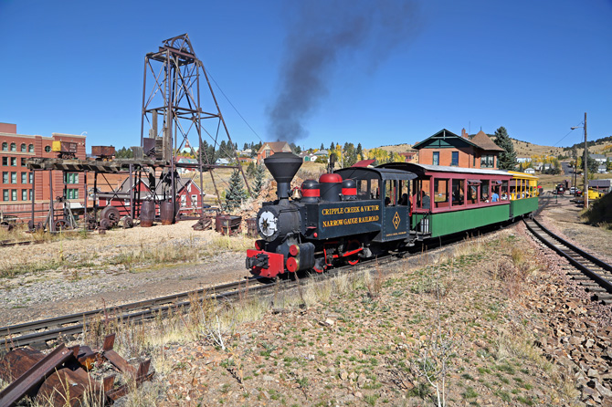 Steam Locomotive Train Ride with historic buildings and mining equipment at the Cripple Creek and Victor Narrow Gauge Railroad in Cripple Creek, Colorado.