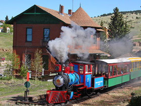 Steam locomotive train passing the depot at Cripple Creek and Victor Narrow Gauge Railroad in Cripple Creek, Colorado.