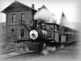 Black and white image of the historic narrow gauge steam locomotive train at Cripple Creek and Victor Narrow Gauge Railroad in Cripple Creek, Colorado.