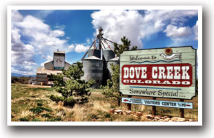 Dove Creek Colorado welcome sign with grain silos in the background