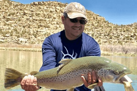 Man holding giant trout caught at Navajo Dam, New Mexico