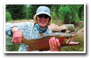 Woman holding rainbow trout she caught in the White River Valley in Colorado