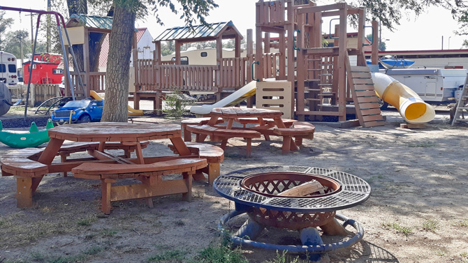 Huge kids playground with wooden fort, swings, slides and picnic tables at Fowler RV Resort in Fowler, Colorado.
