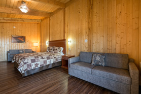 Inside view of deluxe-plus room with king size bed, pull-out sofa and full kitchen at Great Sand Dunes Lodge in Alamosa, Colorado.