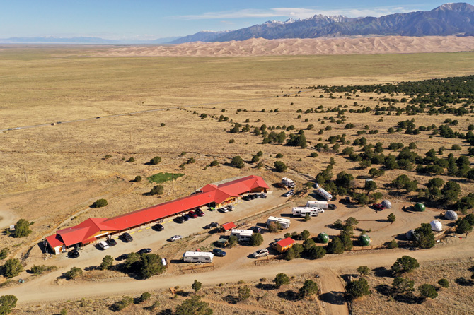 Arial view of Great Sand Dunes Lodge with the Great Sand Dunes National Park and snow capped Sangre De Cristo Mountains in the background located in Alamosa, Colorado.