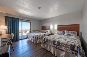 Inside view of standard room with 2 queen size beds, mini-fridge and microwave at Great Sand Dunes Lodge in Alamosa, Colorado.