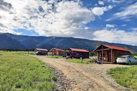 View of Oasis Hillside camper cabin rentals with picnic tables, bbq grills and fire pits at Great Sand Dunes Oasis Campground and RV Park near Alamosa in Mosca, Colorado.