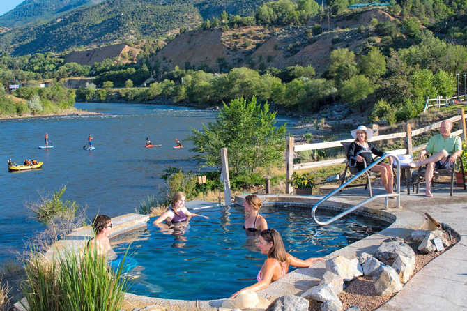 woman relaxing in a hot spring overlooking the Colorado River at Iron Mountain Hot Spring in Glenwood Springs, Colorado