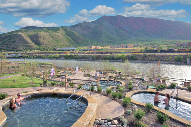 woman relaxing in a hot spring overlooking the Colorado River at Iron Mountain Hot Spring in Glenwood Springs, Colorado