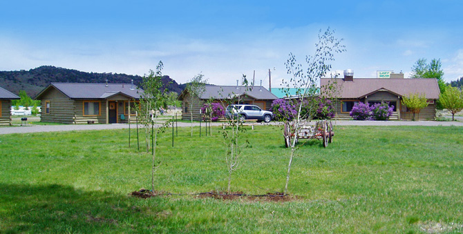 View across lawn of log cabins at Lazy Bear Cabins in South Fork, Colorado