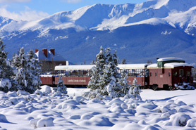 Leadville Colorado and Southern Railroad Winter Holiday Express Train blanketed in snow with blue skies near Leadville and Twin Lakes area in Colorado
