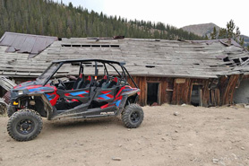 UTV rented with BV Jeeps and ATVs in front of abandoned historical building near Buena Vista, Colorado