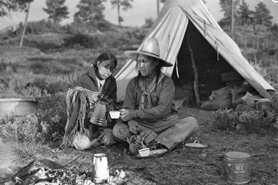 Antique black and white photo of the Jicarilla Apachean Nation people sharing coffee in front of a teepee near Dulce, New Mexico.