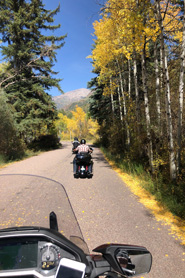 Motorcycling along the West Elk Loop Scenic Byway with aspen trees during the fall near Redstone, Colorado.