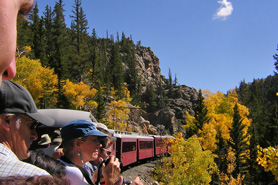 Passengers enjoying the view from an uncovered car aboard the Cumbres and Toltec Narrow Gauge Train between Antonito, CO and Chama, NM.