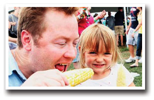 Father and Daughter eating Colorado Olathe Corn