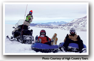 Snow Tubers being pulled by a snowmobile from High Country Tours in Summit County, Colorado. Photo courtesy of High County Tours.