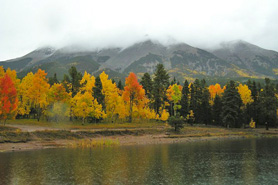 Spanish Peaks surrounded in mist with trees changing to fall colors