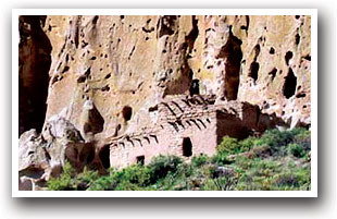 Ruins of a structure with cliff wall in background at Bandelier National Monument, New Mexico