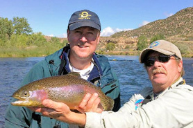 Fishing guide and fisherman with caught rainbow trout in Navajo Dam, New Mexico
