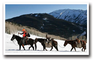 Hunter leads two pack horses into the snowy mountains of the North Fork Valley, Colorado