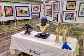 Table of sculptures and a variety of art types on display at the Ouray County Arts Association - Annual Artists Alpine Holiday Art Show in Ouray, Colorado.