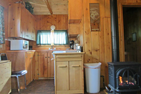 View of kitchen and gas fireplace inside of cabin 3 at Archer's Poudre River Resort in the Poudre River Canyon near Fort Collins, Colorado