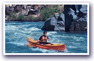 Kayaker floating down Piedra River canyon with rapids ahead of them