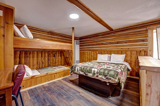 View of lodge room with bunk and queen beds at Rainbow Lodge, Cabins and RV Park in South Fork Colorado.